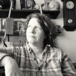 Woman, author of the blog, sitting in a room, looking up thoughtfully