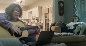 Two women singing in a living room.