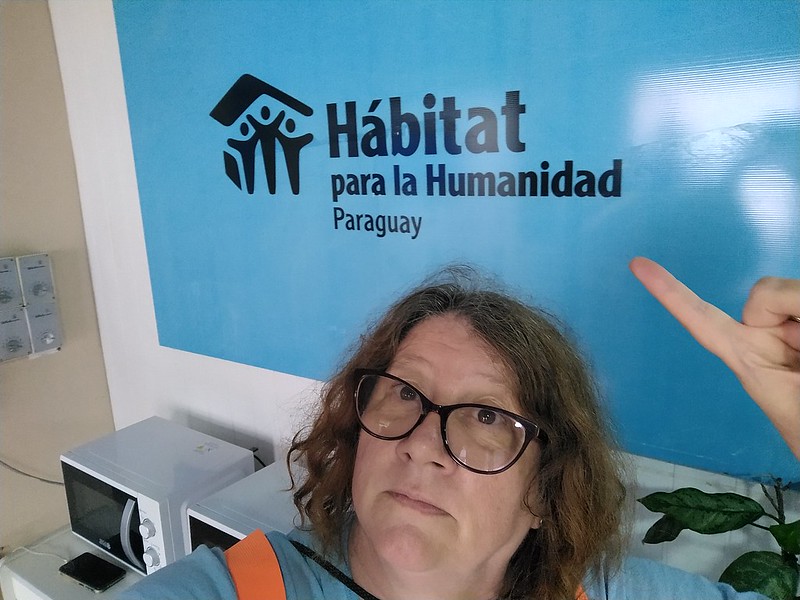 Woman posting in front of a sign that said Habitat para la Humanidad