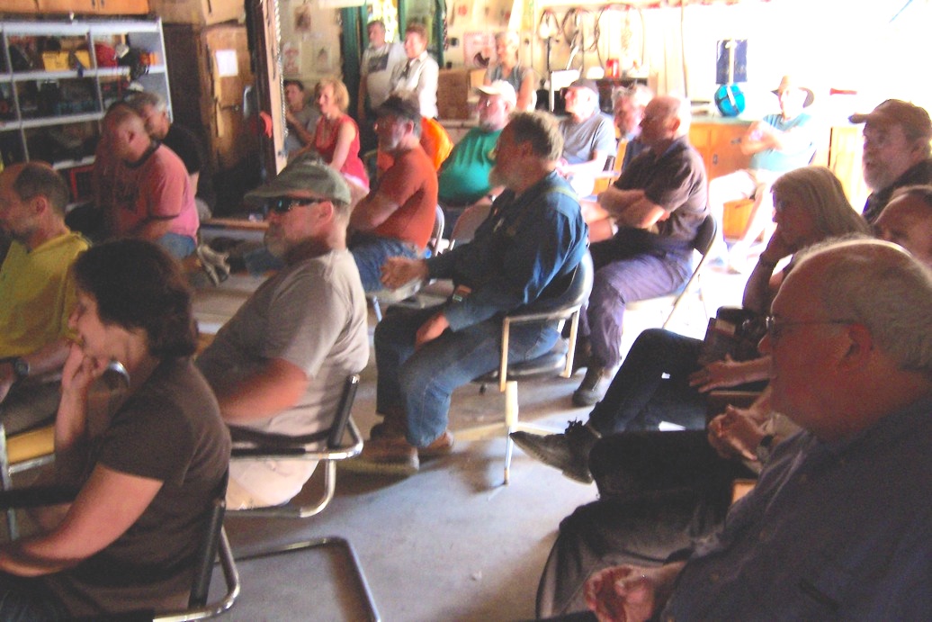 a garage is
        full of people sitting in chairs listening to something